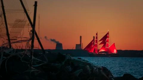 A ship with red sails at sunset on the background of a beautiful orange sky Fotos Stock