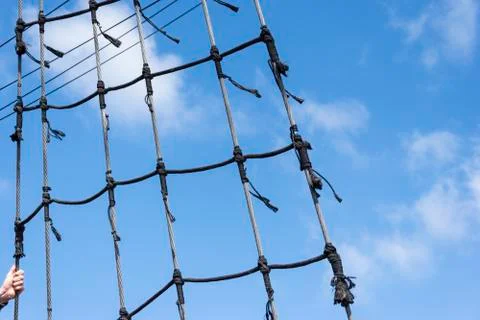 Ship rigging on a blue sky background with the hand holding the line Stock Photos
