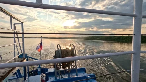 A ship with the Russian flag is sailing along the river. Sunset on the river. Stock Footage 327797313