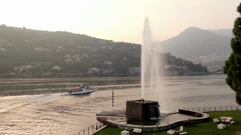 A ship is sailing on Lake Como amid Italian houses among trees at sunset Stock Footage 128814724