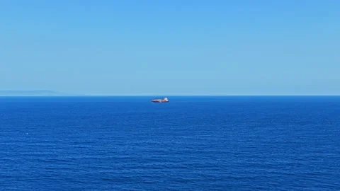 Ship sailing on open sea in bright blue water during clear weather Stock Footage 344823479