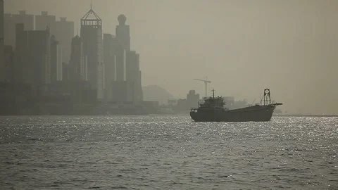 Ship sailing in the river in front of Hong Kong skyline on a hazy day Stock Footage 97382083