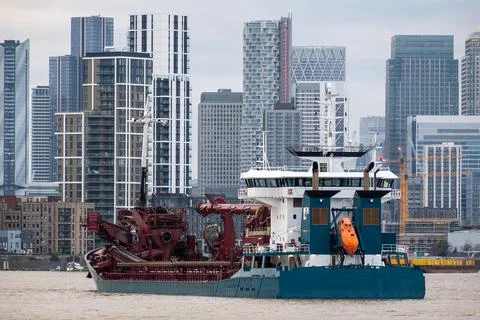 Ship sailing on river Thames past Canary Wharf, London, England, UK Stock Photos