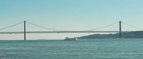 A ship sailing under a bridge in Lisbon Stock Footage 151391028