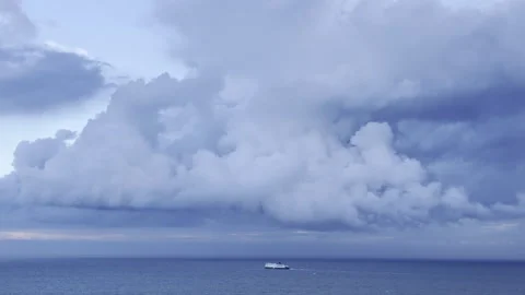 Ship sailing under massive storm clouds panning Stock Footage 336517852