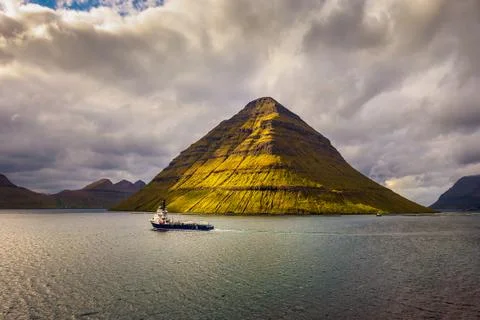 Ship sails along the island of Kunoy in the Faroe Islands, Denmark Foto stock