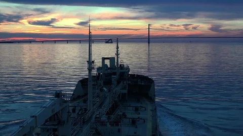 Ship sails in direction to long bridge and beautiful sunset Stock Footage 113093806