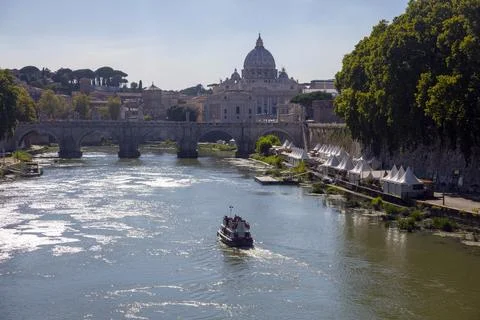 The ship sails down the Tiber River with a view of the bridge and the old V.. 스톡 사진