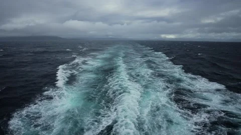 As the ship sails forward, the wind whisks off the crests of waves, turning them Stock Footage 252337244