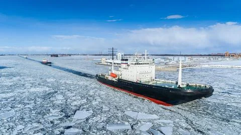 Ship sails on an ice-bound bay. Winter seafaring. Stock Photos