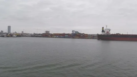 Ship sails past lighthouse yachts boats and port facilities Stock Footage 148388782