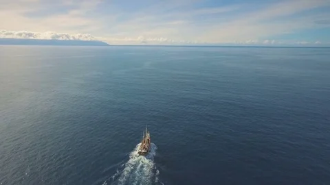 A ship with sails sailing into the sunset Видео 74789052