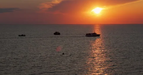 The Ship sails into the Sea against the backdrop of Sunset. 8k Stock Footage 259493815