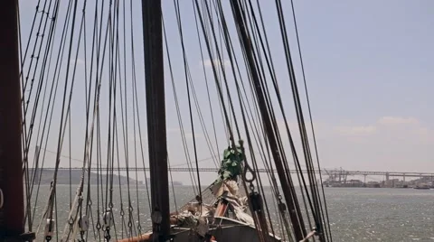Ship sails through the waves on a bridge background Lisbon Stock Footage 64577450