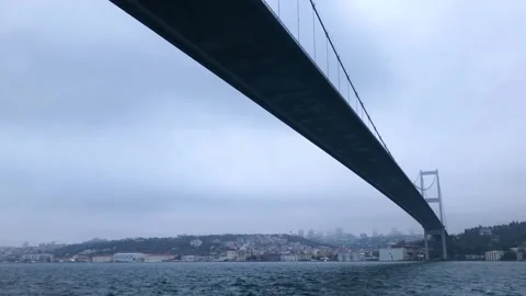 The ship sails under the Bosphorus bridge. Bosphorus bridge view from below. Stock Footage 218464228