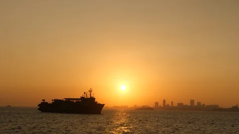 Ship at sea with backdrop of Mumbai at sunset. India. Stock Footage 129078729