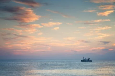 Ship in the sea at sunset Stock Photos
