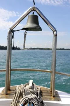 Ship at sea with view of lighthouse deck and bell Stock Photos