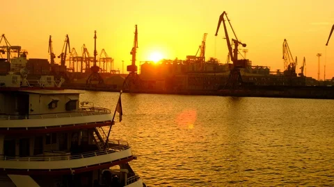 The ship stands on the pier on the background of cargo cranes. Dawn on the coast Stock Footage 98030961