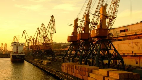 The ship stands on the pier on the background of cargo cranes. Dawn on the coast Stock Footage 98031372