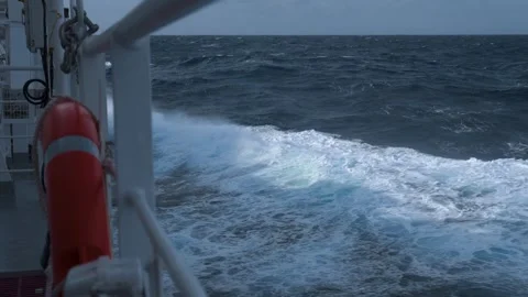 Ship in storm. High waves and splashes along side. White foam on sea. Deck Stock Footage 243388365