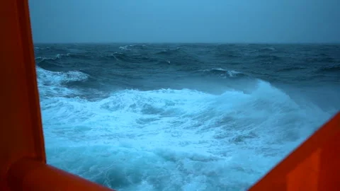 Ship in storm. Strong wind breaks wave. Red side of vessel and green sea. Stock Footage 274001111