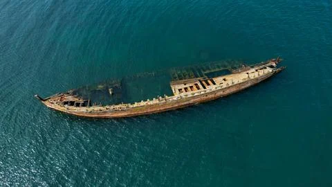 A ship stranded washed by waves near the shore, footage taken from the air on a  Stock Photos