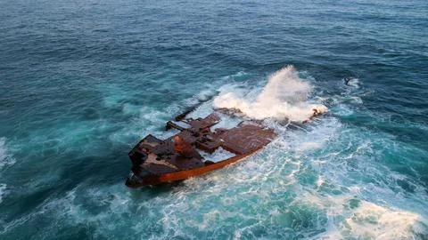 A ship stranded washed by waves near the shore, footage taken from the air on a Stock Photos