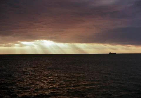 Ship under a dramatic sky on the ocean Stock Photos