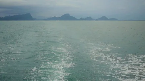 Ship wake on the ocean. Water foam trace behind the large ship goes till the Stock Footage