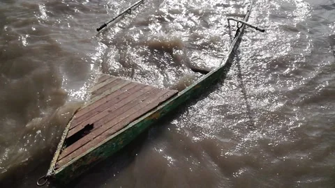 The ship was wrecked with a rope attached to the pillar by the river. Stock Footage 140096397