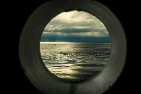 Ship window or porthole view with a relaxing seascape and dark grey clouds Stock Illustration