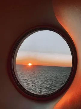 Ship window overlooking stunning ocean sunset Stock Photos
