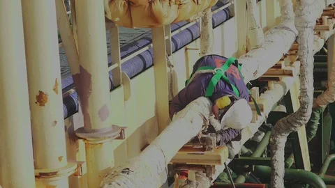 Ship worker removes rust lying on pipe of oil tanker Stock Footage 121117591