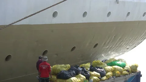 Ship worker throw a plastic garbage Stock Footage 200130814
