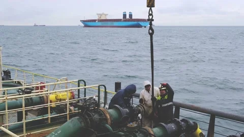 Ship workers in protective costumes connect product pipeline Stock Footage 131605919