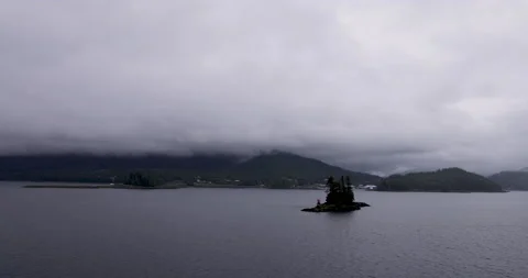 Shipboard view passing tiny dark island approaching Ketchikan Stock Footage 209621078