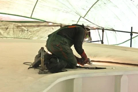 Shipbuilder is working on the deck, protected by an awning. Foto stock