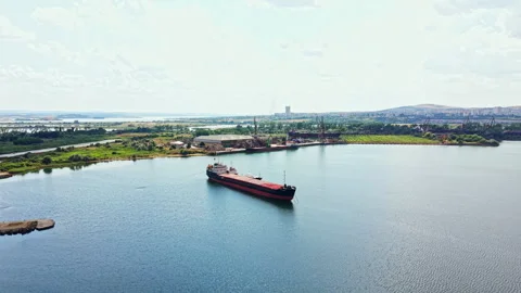 Shipbuilding activity occurs near a large body of water with a ship docked while Stock Footage 340930719