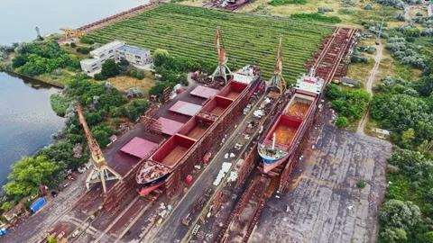 Shipbuilding yards show activity with workers and cranes in the summer season at Stock Footage 341108504