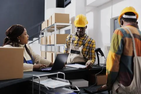 Shipment manager asking warehouse workers about merchandise storage system Stock Photos