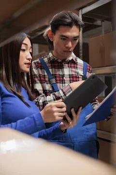 Shipment operators managing warehouse workflow optimization on digital tablet Stockfoto's