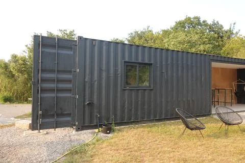 Shipping container converted into tiny house with open door Stock Photos