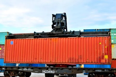 Shipping container loading by richtracker on the freight rail car Foto stock
