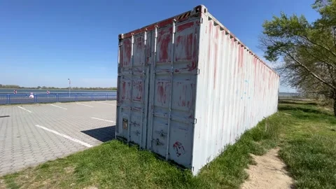 Shipping Container Sitting next to a Parking Lot Sunny 4k Stock Footage 183424408