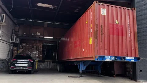 Shipping Container Trailer at Urban Warehouse Loading Dock with Parked Car in Stock Footage 338405345