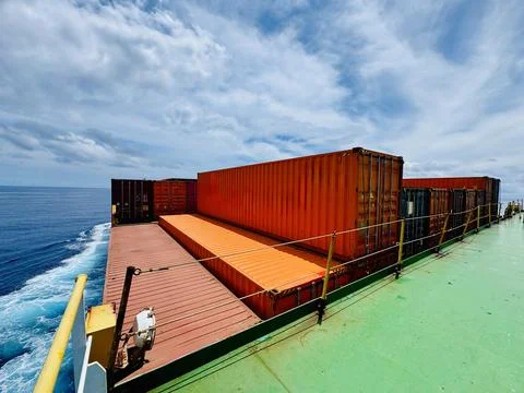 Shipping Containers on Deck of Container Ship Sailing Across Open Ocean Foto stock
