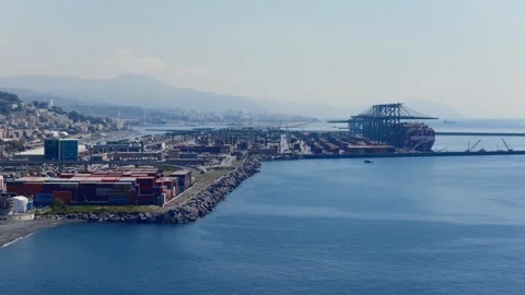 Shipping containers stack along Genoa industrial port beside towering gantry Stock Footage 346455844