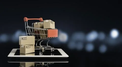 Shipping paper boxes inside Red shopping cart trolley on tablet with black Stock Photos