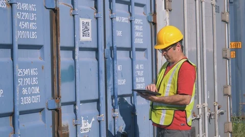 Shipping Worker Working With a Tablet Computer In His Hands in Shipping Yard Stock Footage 93461883
